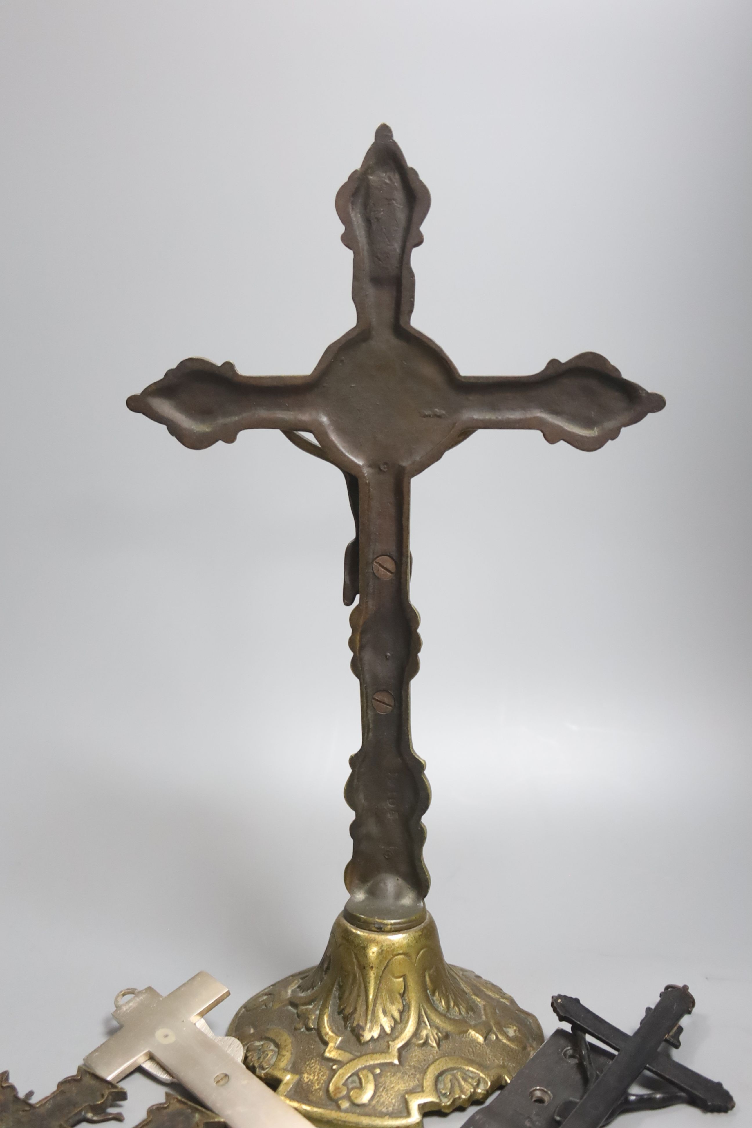 A group of four brass and metal crucifixes, largest 34cm
